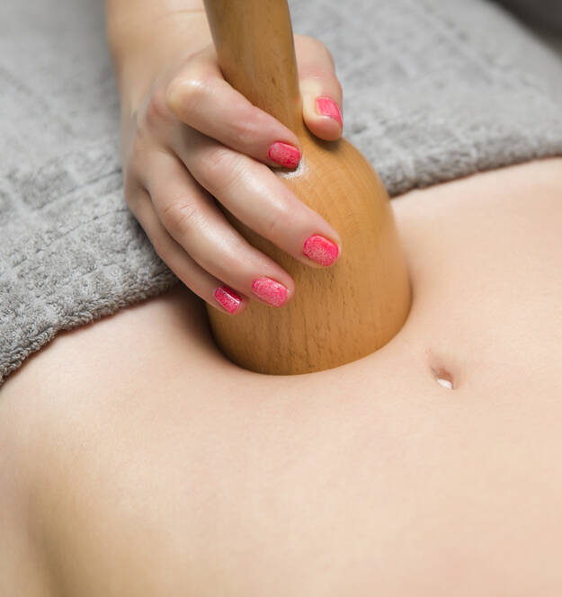 Young woman doing maderotherapy massage treatment at spa salon